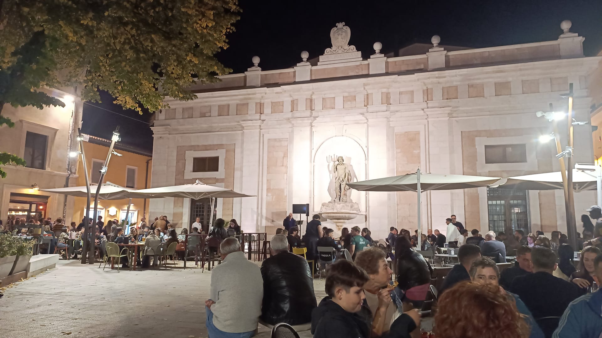 Piazza animata la sera con tavolini